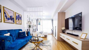 Ein modernes Wohnzimmer mit einem blauen Sofa, einem Couchtisch und einem Fernseher auf einer Holzkabine.
