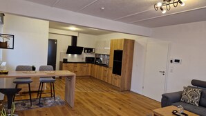 A modern apartment with a dining area, kitchen, and living room.