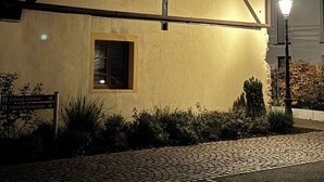 Une maison traditionnelle à colombages, avec une petite fenêtre et un chemin pavé devant.