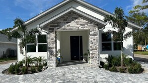 A building with a stone facade, a central entrance, and a paved driveway.