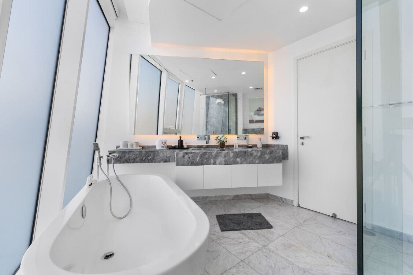 A modern bathroom with a freestanding bathtub, a vanity with a mirror, and a glass shower enclosure.