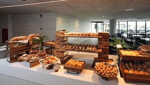 Un bufé con una variedad de productos horneados y pastelería exhibidos sobre puestos de madera.