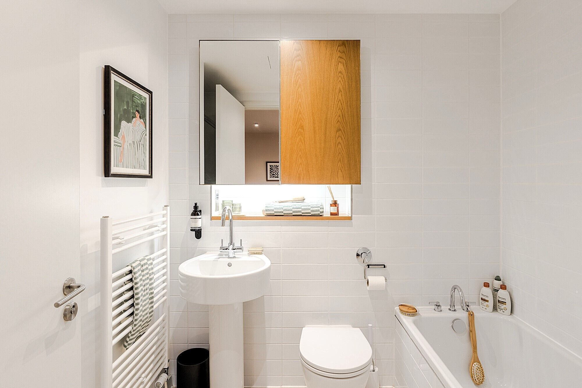 A modern bathroom with a white sink, a toilet, and a bathtub.