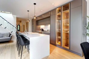 Una cocina moderna con una isla central, taburetes de bar y armarios empotrados.