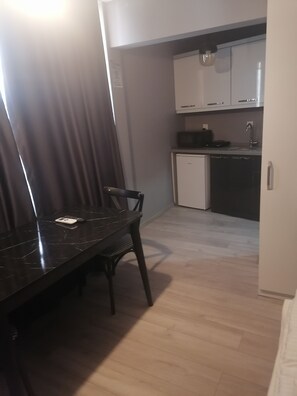 A compact kitchen with a dishwasher, a small countertop, and cabinets. - Opera Wall Suite (Istanbul)