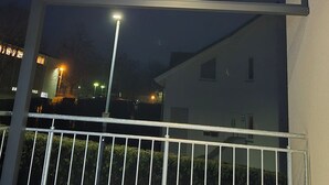 A covered outdoor area with a metal railing and a series of lights on the ceiling.