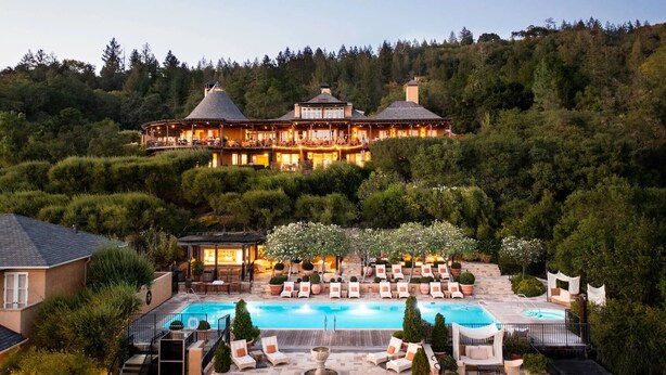 A large resort with a swimming pool, outdoor seating, and a forested hillside backdrop. - Silverado Napa Retreat, by Vinifera Homes (Napa)