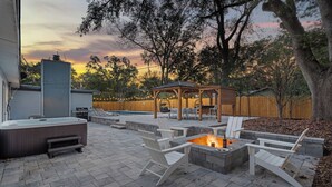 A backyard with a hot tub, fire pit, and outdoor seating area. - Gator Grove (Gainesville)