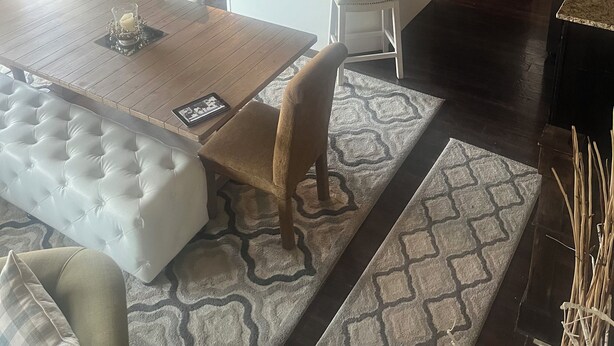 Una cocina moderna con armarios oscuros, encimera de granito y electrodomésticos de acero inoxidable.