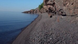A rocky beach with a clear blue sky.