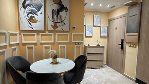 A modern dining area with a round table, black chairs, and artwork on the walls. - Luxury apartment in Agdal free Netflix and garage (Rabat)