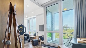 A spacious living area with large windows, a wooden floor, and a modern design. - Apartment Kozlík by Interhome (Abertamy)