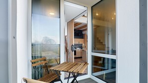 A modern balcony with wooden furniture and a view of the interior. - Apartment Kozlík by Interhome (Abertamy)