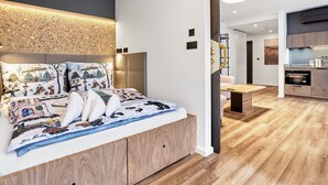 Een moderne slaapkamer met een groot bed, een houten hoofdbord en een decoratief wandpaneel.