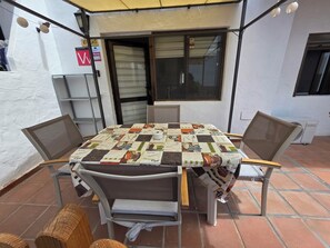 A patio area with a table covered by a coffee-themed tablecloth, surrounded by chairs. - Casa Samba, 2 Bedrooms and Pool (La Oliva)