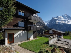 A two-story chalet with a balcony, a garage, and a mountain view.