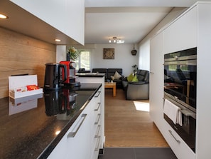 A modern kitchen with a black countertop, white cabinetry, and a built-in oven.