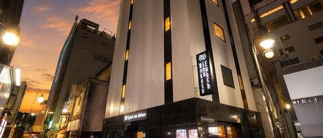 A modern building with a prominent vertical light strip and signage indicating a business establishment.