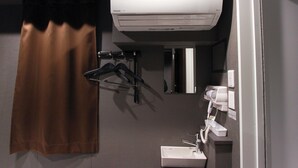 A bathroom with a towel hanging, a hairdryer, and a mirror. - Epoch inn Nakasu (Fukuoka)