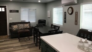 A dining area with a table, chairs, and a kitchen counter. - Spacious 4-bedroom house with AC, fitness equipment in wonderful Lakeside (Lakeside)