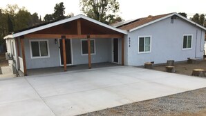 A two-story house with a covered garage, a concrete driveway, and a number '9018' on the side. - Spacious 4-bedroom house with AC, fitness equipment in wonderful Lakeside (Lakeside)