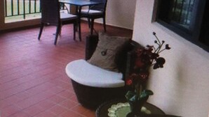 Et værelse med balkon, et bord med stole og en sofa.