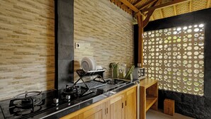 A kitchen with a black countertop, wooden cabinets, and a brick wall.