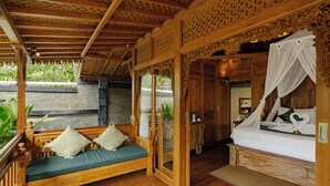 A wooden room with a bed, a bench, and a window.