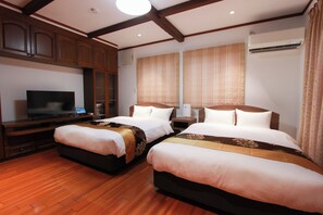 A hotel room with two beds, wooden flooring, a TV, and an air conditioning unit. - HOTEL DO-YA BEPPU Bekkan (Beppu)