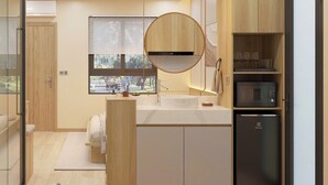 Una cucina moderna con isola centrale, forno a microonde integrato e frigorifero.