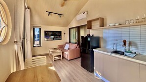 Una cucina moderna con frigorifero integrato, un tavolo da pranzo in legno e una ventola a soffitto.
