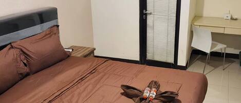 Una habitación de hotel con una cama, un escritorio y una silla.