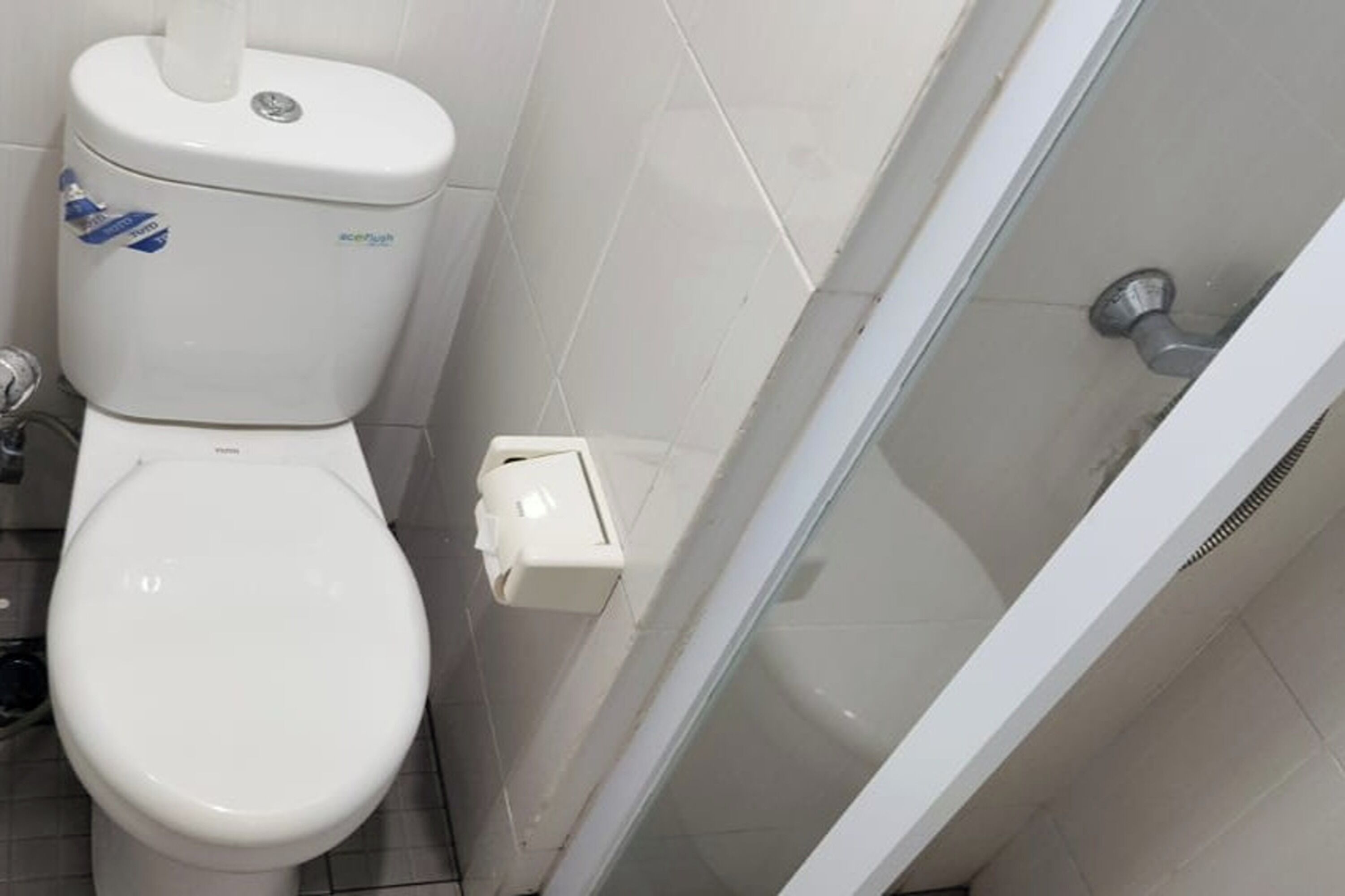Ein Badezimmer mit Toilette, Bidet und Duschkabine aus Glas.