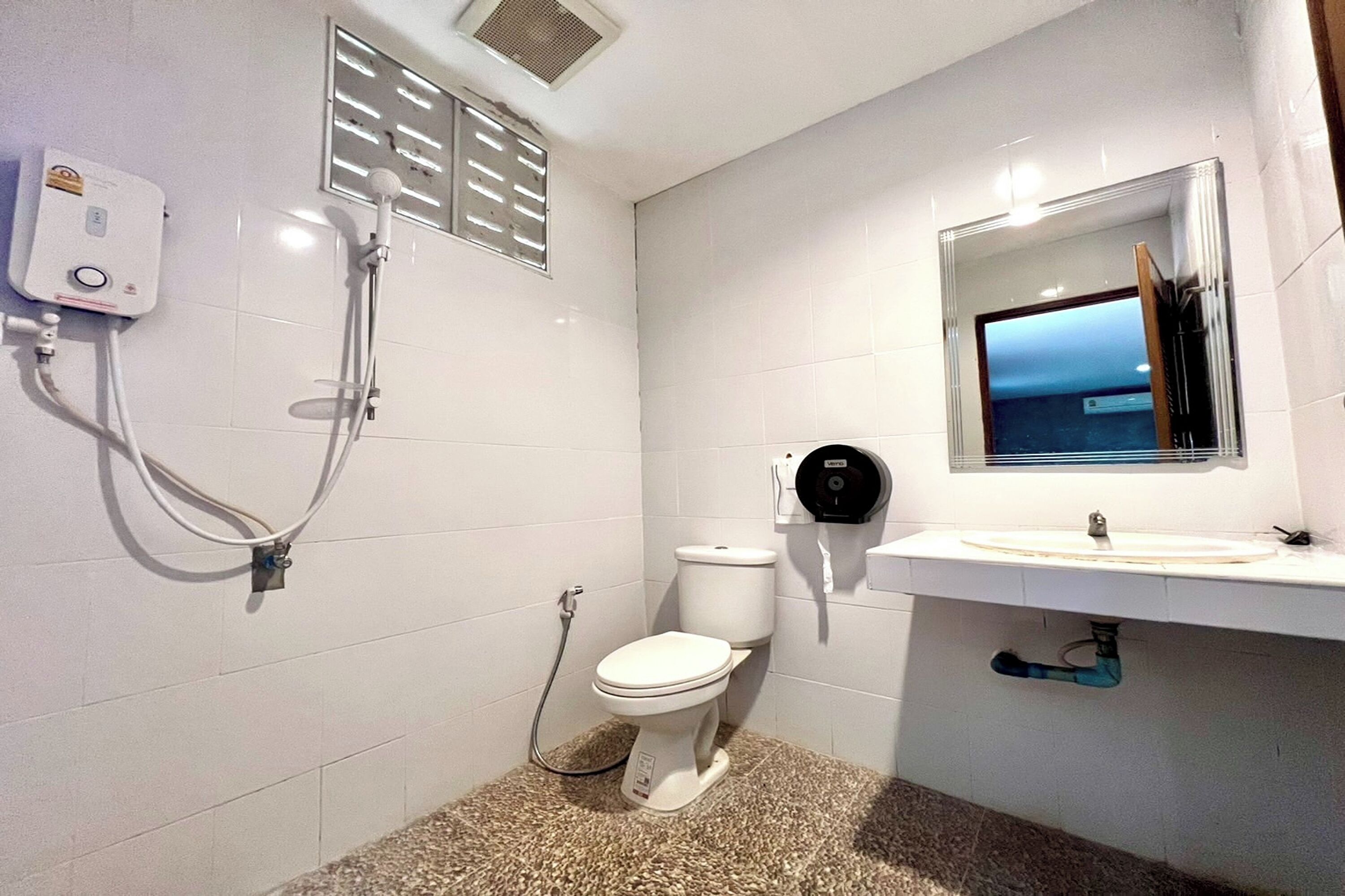 Ein Badezimmer mit Toilette, Waschbecken und Dusche.