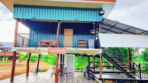 A two-story building with a balcony and a sign in a local language. - Jira Hotel (Lampang)