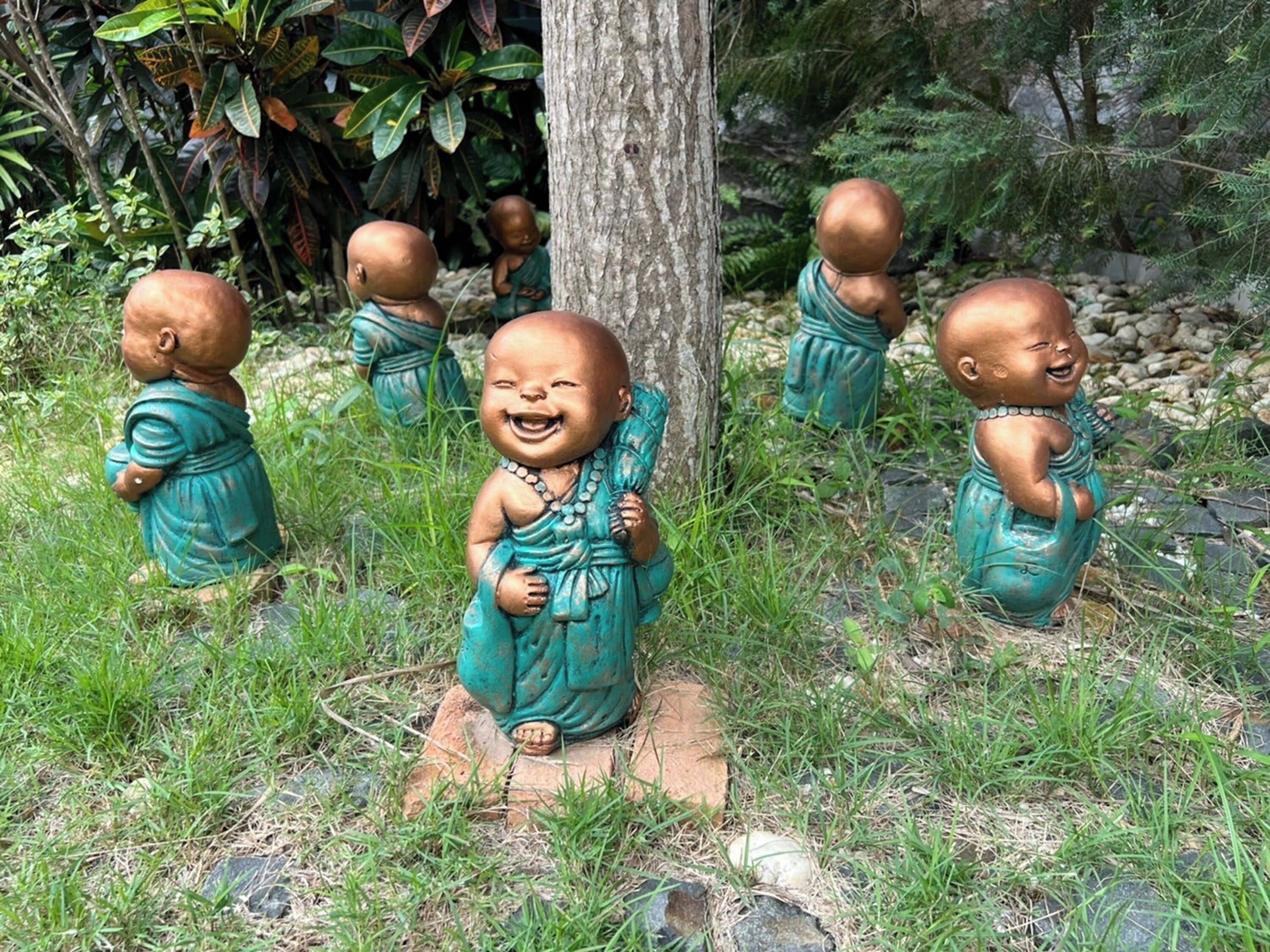 Un jardín con estatuas de niños con trajes tradicionales.