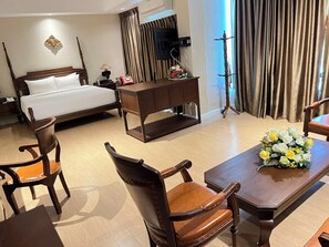 Ein Hotelzimmer mit einem Bett, Holzmöbeln, einem Schreibtisch und einem Fernseher.