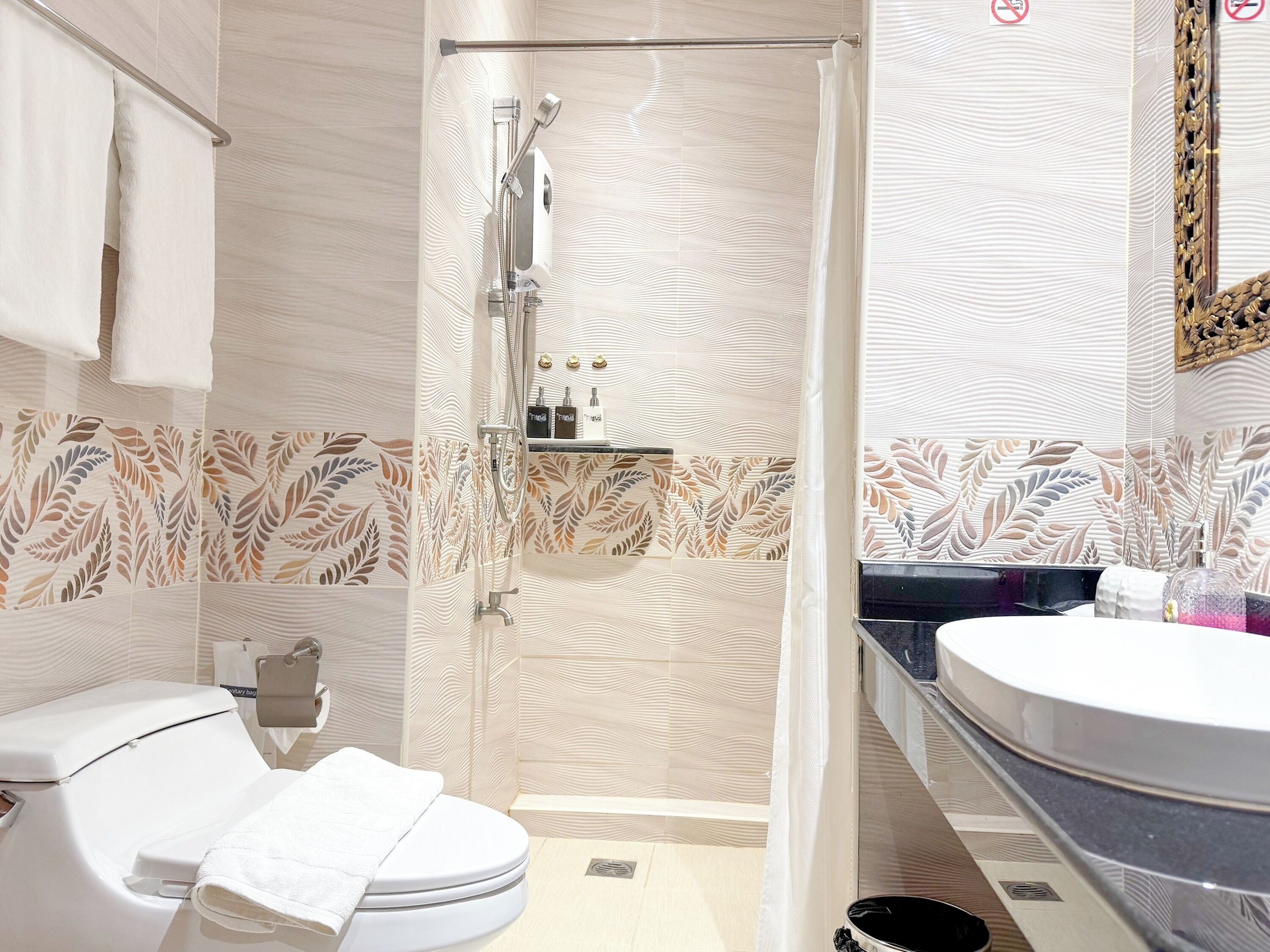 A modern bathroom with a shower, toilet, and sink.
