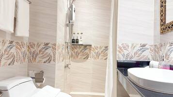 A modern bathroom with a shower, toilet, and sink.