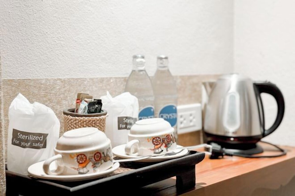 A coffee station with a kettle, cups, and sterilized bags.