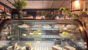 Vitrina de pastelería con diversos postres a precios de 25, 40 y 65 centavos.