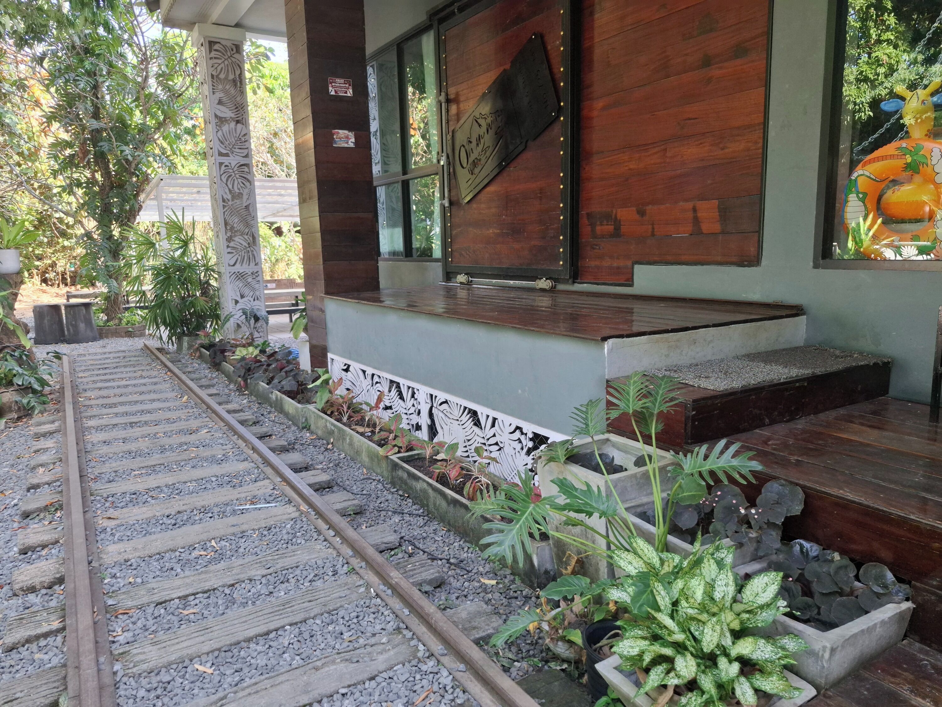 Fachada de madera con una escalera metálica que sube a un porche.