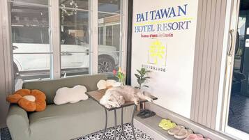 A hotel entrance with a sofa, a table, and a sign for Paiwan Hotel Resort.