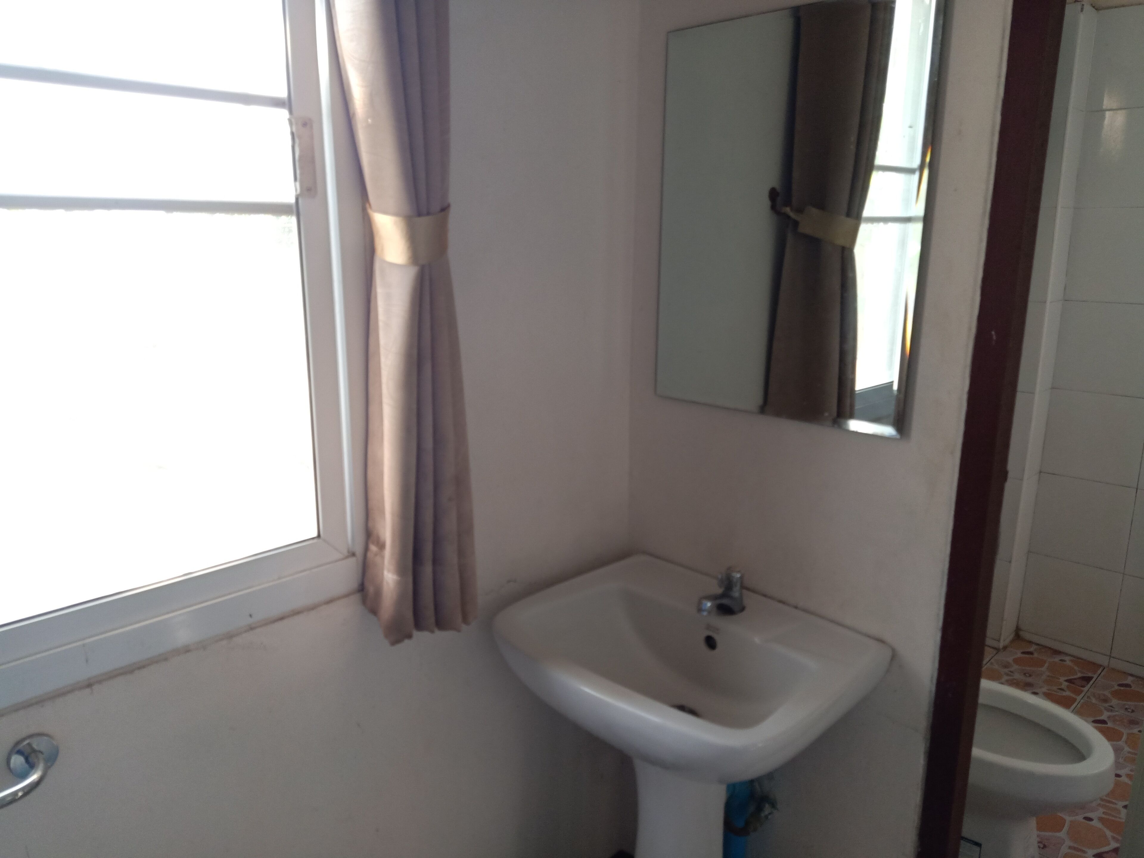 Un baño con lavamanos, espejo y retrete.