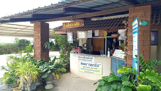 A small, rustic building with a tiled roof and brick walls. There are several potted plants outside, and a signboard with text in a non-Latin script. - Phumchan Place Hotel (Phayao)