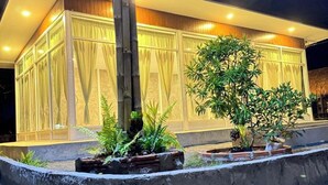 A modern building with large windows and a well-lit facade. - The Forest Hill Cafe & Homestay (San Sai)