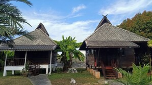 Two wooden cabins with tiled roofs, surrounded by greenery and a clear sky. - The Forest Hill Cafe & Homestay (San Sai)