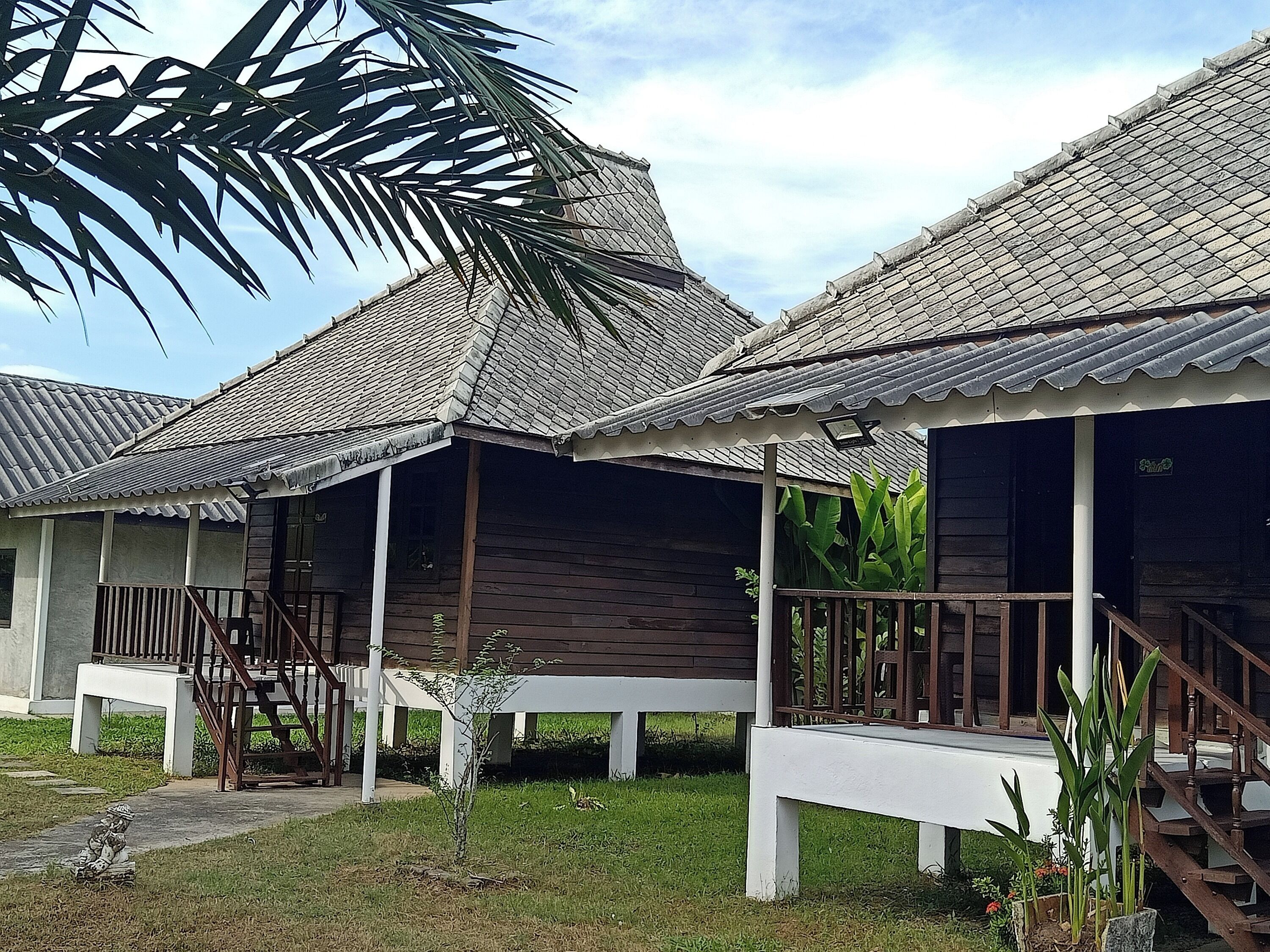 A row of wooden cabins with tiled roofs and white railings.