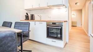 A modern kitchen with white cabinets, a built-in oven, and a coffee machine. - Rothaarsteig by Interhome (Winterberg)