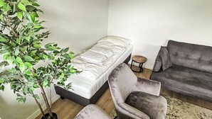 A modern living room with a sofa, a chair, a small table, and a potted plant. - Rothaarsteig by Interhome (Winterberg)